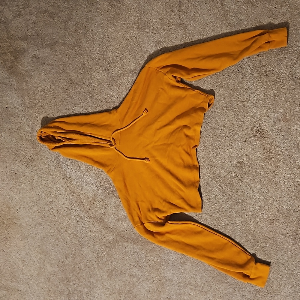 This is a mustered colored cropped hoodie.